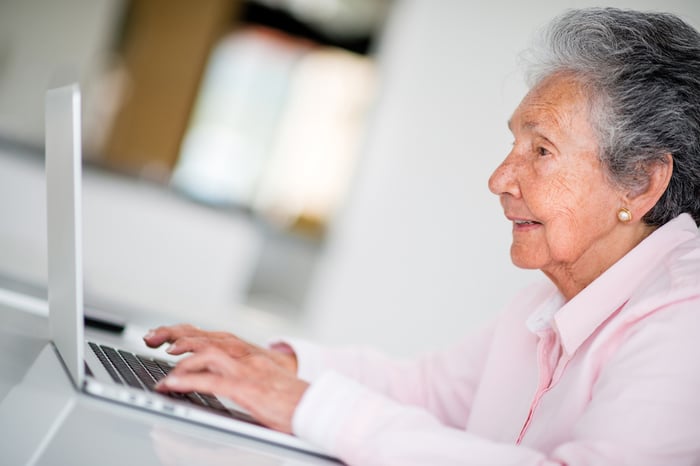 Elder woman using a computer and looking very happy